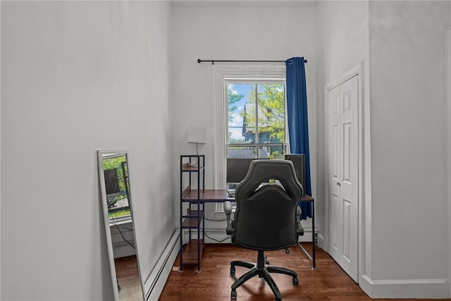 home office featuring a baseboard heating unit, wood finished floors, and baseboards