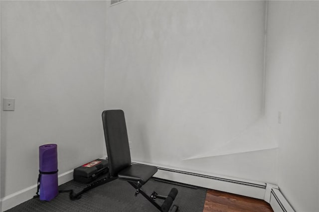 workout area featuring a baseboard heating unit and baseboards