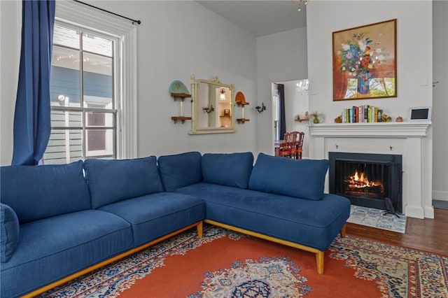 living area with wood finished floors and a fireplace with flush hearth