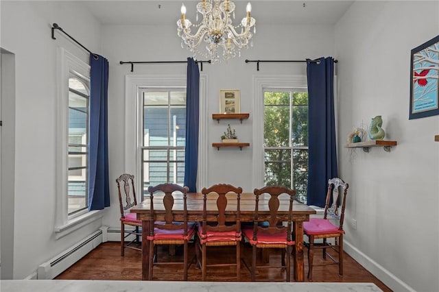 dining area with a chandelier, a baseboard heating unit, wood finished floors, and baseboards