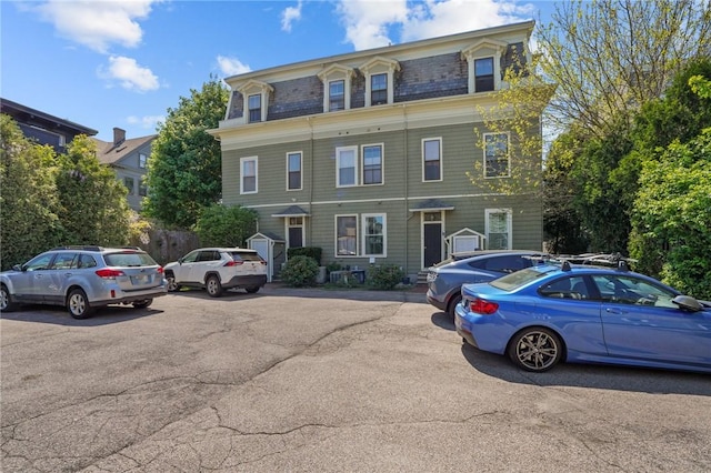 view of front of home featuring mansard roof and uncovered parking