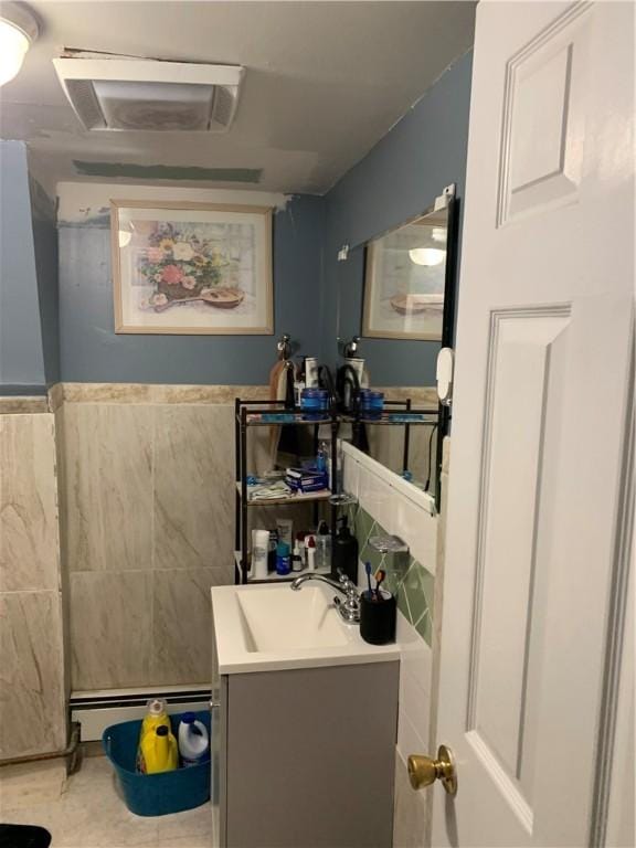 31 Ponagansett Ave, Providence, RI 02909 - bathroom featuring vanity, visible vents, wainscoting, tile walls, and a baseboard radiator