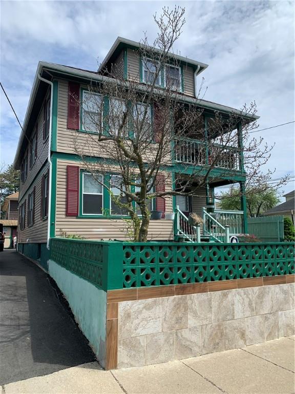 31 Ponagansett Ave, Providence, RI 02909 - view of front of property featuring covered porch, a fenced front yard, and a balcony
