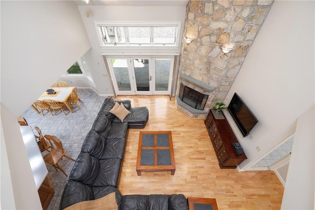 825 Woonsocket Hill Rd, North Smithfield, RI 02896 - living area featuring french doors, a fireplace, wood finished floors, baseboards, and a high ceiling