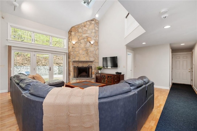 825 Woonsocket Hill Rd, North Smithfield, RI 02896 - living area featuring high vaulted ceiling, a stone fireplace, french doors, light wood-style flooring, and baseboards