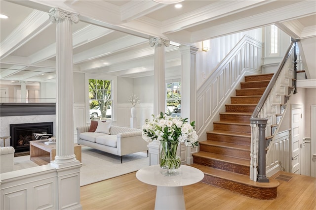 349 Wayland Ave, Providence, RI 02906 - staircase featuring a decorative wall, ornate columns, wood finished floors, beamed ceiling, and a glass covered fireplace