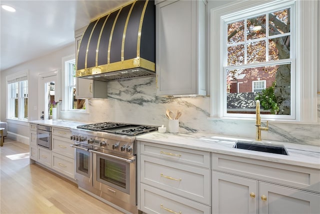 349 Wayland Ave, Providence, RI 02906 - kitchen with range with two ovens, light wood finished floors, backsplash, and light stone counters
