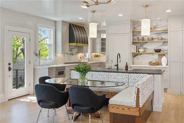 349 Wayland Ave, Providence, RI 02906 - kitchen with custom exhaust hood, a sink, open shelves, tasteful backsplash, and decorative light fixtures