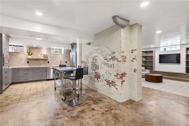 349 Wayland Ave, Providence, RI 02906 - kitchen with gray cabinets, concrete floors, decorative backsplash, appliances with stainless steel finishes, and recessed lighting