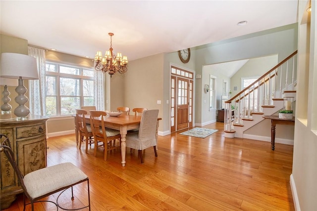 27 Tom Harvey Rd, Westerly, RI 02891 - dining room featuring a chandelier, light wood-style floors, stairway, and baseboards