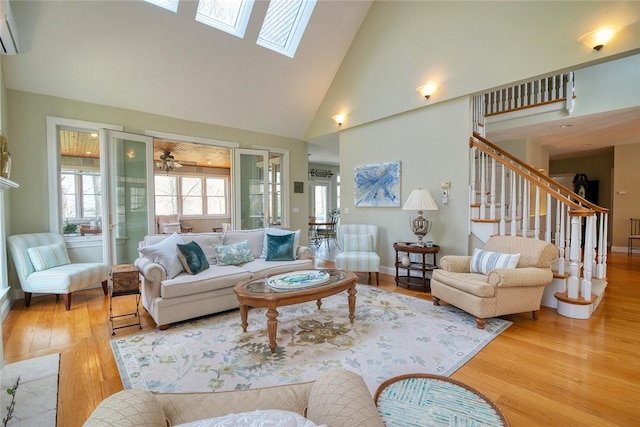 27 Tom Harvey Rd, Westerly, RI 02891 - living room featuring high vaulted ceiling, wood finished floors, stairway, a wall unit AC, and a skylight