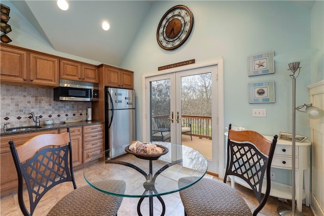27 Tom Harvey Rd, Westerly, RI 02891 - kitchen with appliances with stainless steel finishes, a sink, high vaulted ceiling, brown cabinetry, and french doors