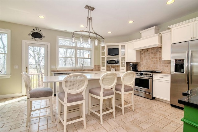 27 Tom Harvey Rd, Westerly, RI 02891 - kitchen with appliances with stainless steel finishes, light countertops, recessed lighting, decorative backsplash, and a breakfast bar
