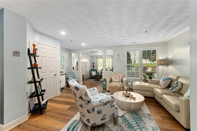 living room featuring recessed lighting, baseboards, and wood finished floors