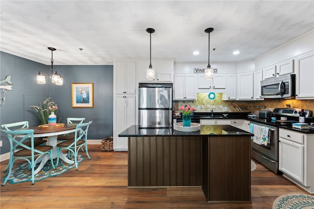 kitchen featuring stainless steel appliances, baseboards, a sink, and a center island