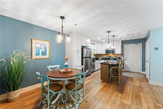 kitchen with white cabinets, stainless steel appliances, baseboards, and dark countertops