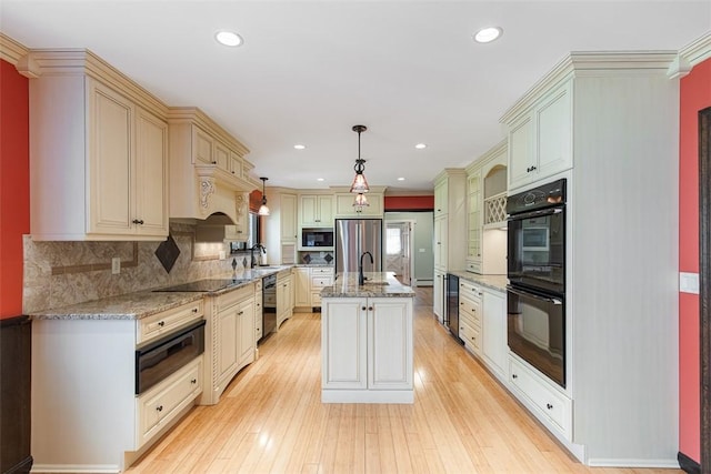 28 Potter Hill Rd, Westerly, RI 02891 - kitchen with black appliances, wine cooler, a warming drawer, cream cabinets, and a kitchen island with sink