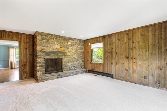 28 Potter Hill Rd, Westerly, RI 02891 - unfurnished living room with wooden walls, carpet, a fireplace, baseboards, and a baseboard heating unit