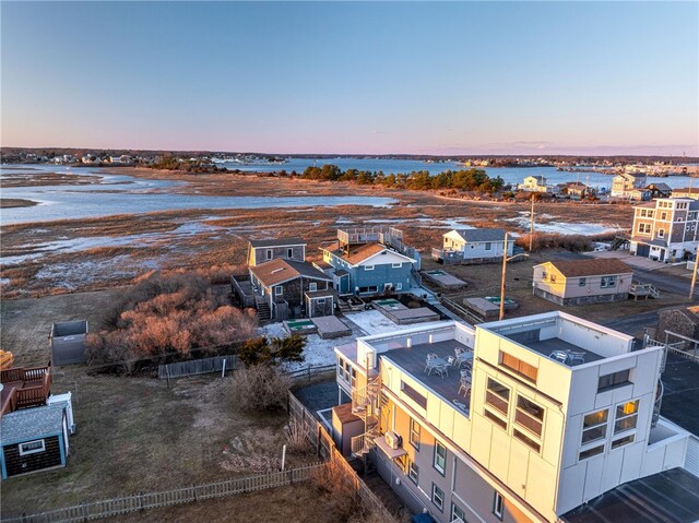 aerial view at dusk featuring a water view