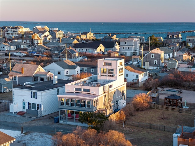 aerial view at dusk featuring a water view