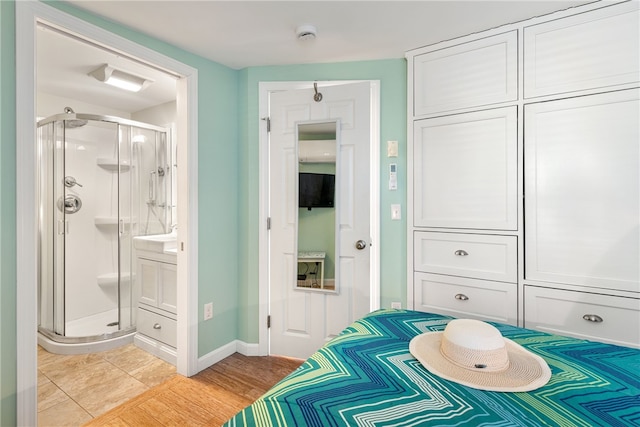 bedroom with baseboards and connected bathroom