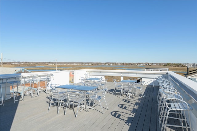 deck featuring outdoor dining area and a water view