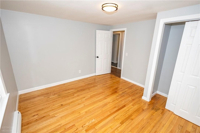 2 King St, Johnston, RI 02919 - unfurnished bedroom with a baseboard heating unit, light wood-style floors, a closet, and baseboards
