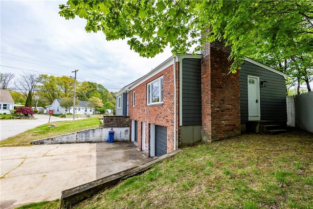 2 King St, Johnston, RI 02919 - view of home's exterior featuring a chimney, an attached garage, and concrete driveway