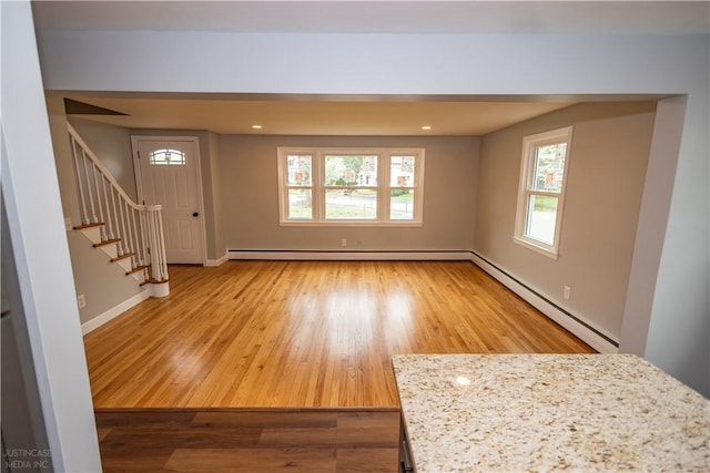 2 King St, Johnston, RI 02919 - unfurnished living room with stairs, wood finished floors, a baseboard heating unit, baseboard heating, and baseboards