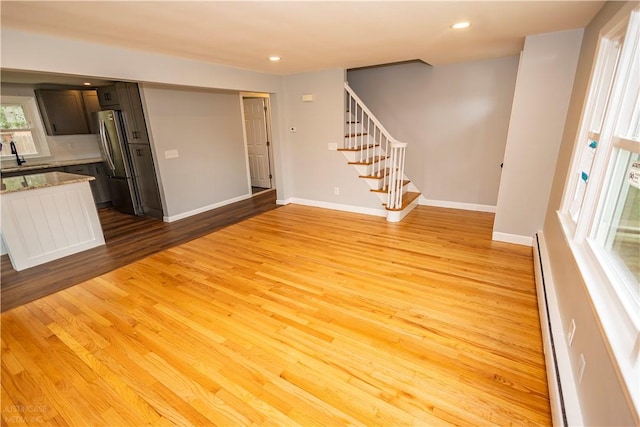 2 King St, Johnston, RI 02919 - unfurnished living room featuring a baseboard heating unit, light wood-style floors, recessed lighting, and stairway