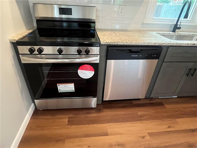 2 King St, Johnston, RI 02919 - kitchen featuring stainless steel appliances, light wood-style floors, decorative backsplash, gray cabinetry, and light stone counters