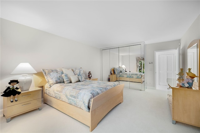 bedroom with light colored carpet and baseboards