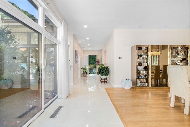 hall with tile patterned flooring, baseboards, visible vents, and recessed lighting