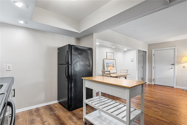 kitchen featuring freestanding refrigerator, wood finished floors, baseboards, and recessed lighting