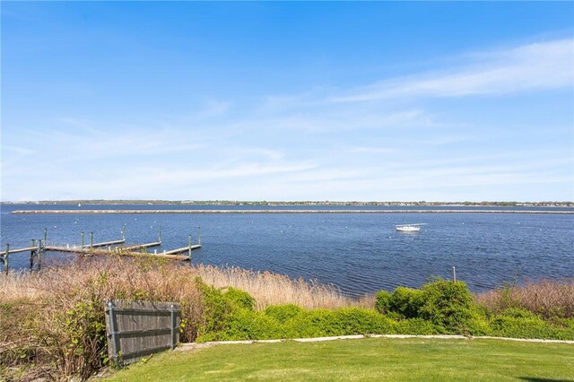 property view of water with fence and a boat dock