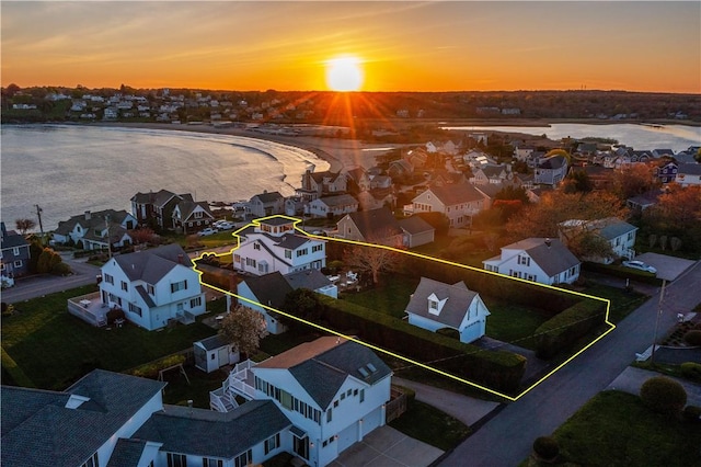 aerial perspective of suburban area with property boundaries highlighted and a nearby body of water