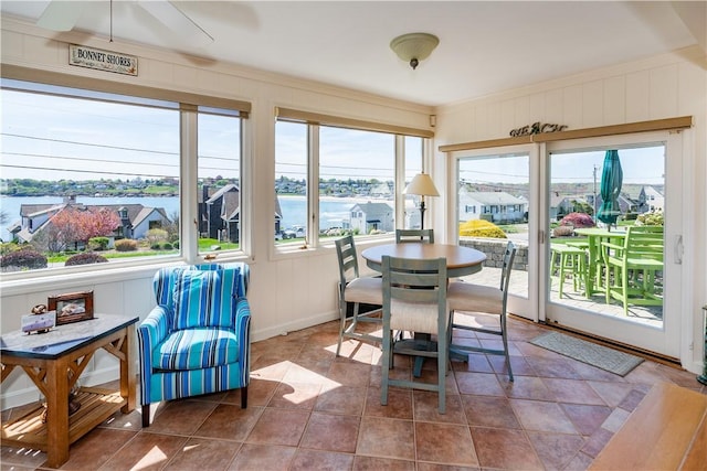 sunroom / solarium with a decorative wall and a water view