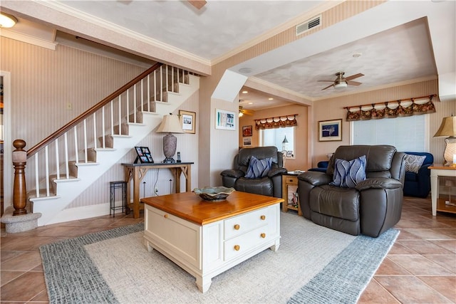 living room with a ceiling fan, stairway, ornamental molding, and light tile patterned floors