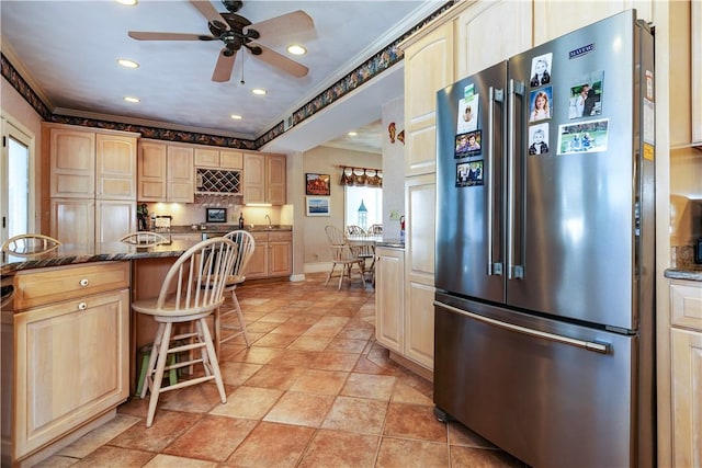 kitchen with freestanding refrigerator, light brown cabinetry, ornamental molding, recessed lighting, and tasteful backsplash