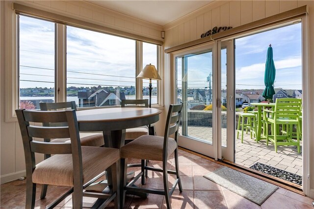 sunroom / solarium featuring ornamental molding and plenty of natural light