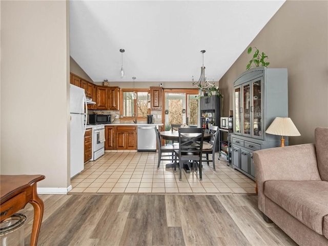 132 Elton Cir, Cranston, RI 02921 - kitchen featuring lofted ceiling, white appliances, brown cabinets, open floor plan, and light countertops