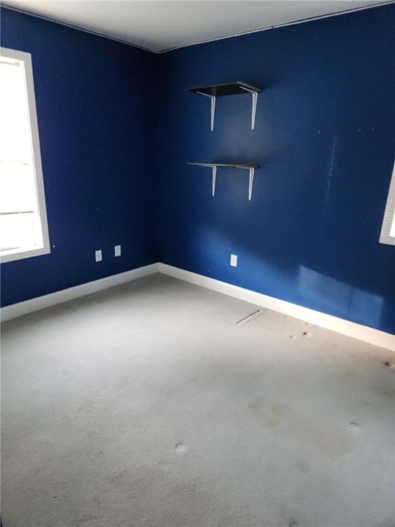 unfurnished room with baseboards