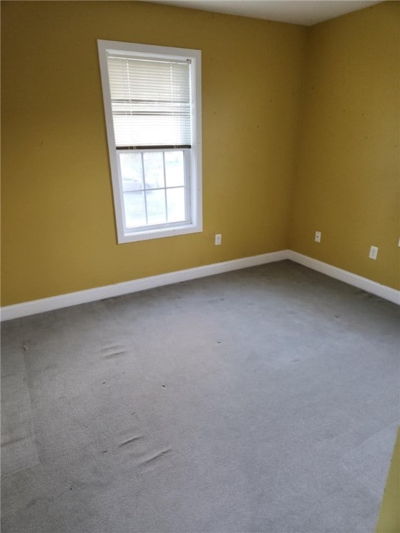 empty room with carpet and baseboards