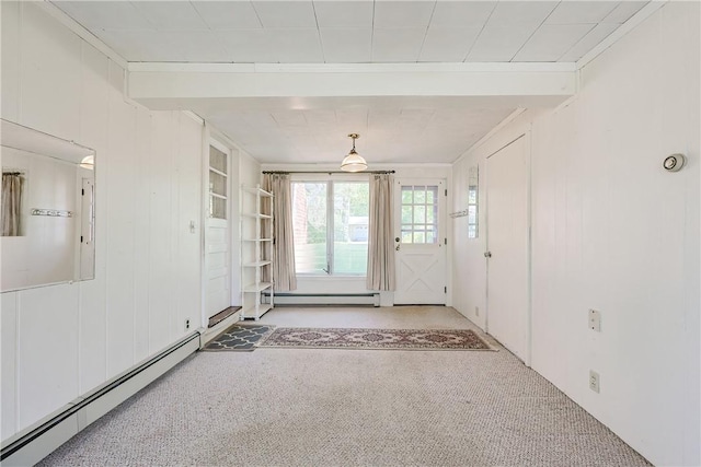 unfurnished room featuring crown molding, wooden walls, a baseboard radiator, and carpet floors