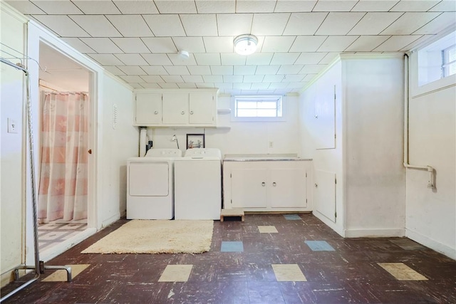 clothes washing area featuring cabinet space, dark floors, plenty of natural light, and independent washer and dryer