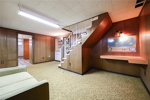 bonus room with baseboards, carpet flooring, wooden walls, and stairway