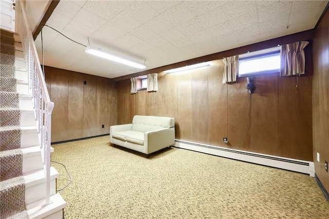 below grade area featuring stairs, baseboard heating, and wood walls