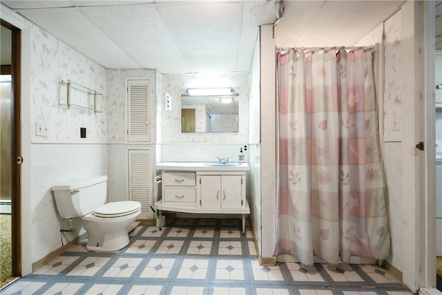 bathroom with toilet, tile patterned floors, vanity, and wallpapered walls