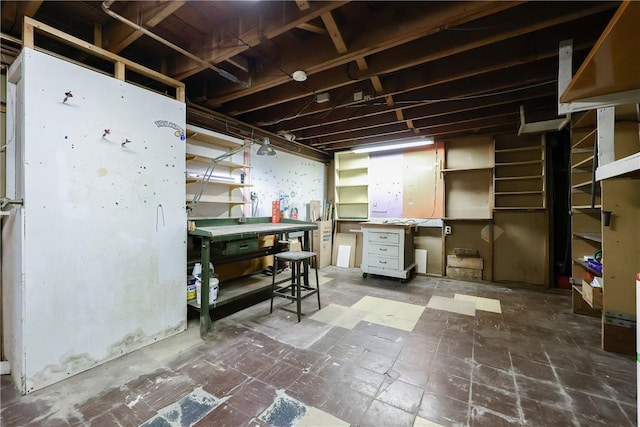 unfinished below grade area featuring tile patterned floors and a workshop area