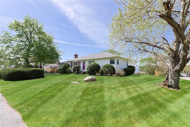 single story home featuring a front lawn and a chimney